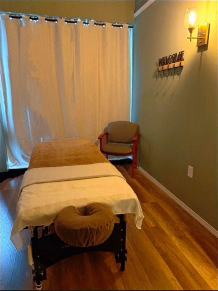 Private massage room with table and Welcome sign